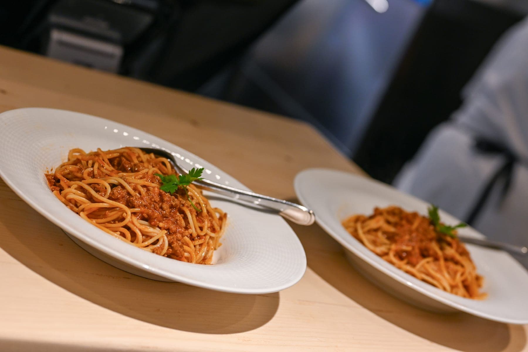 Two plates of pasta set down on a wooden table at Mikri Avra.