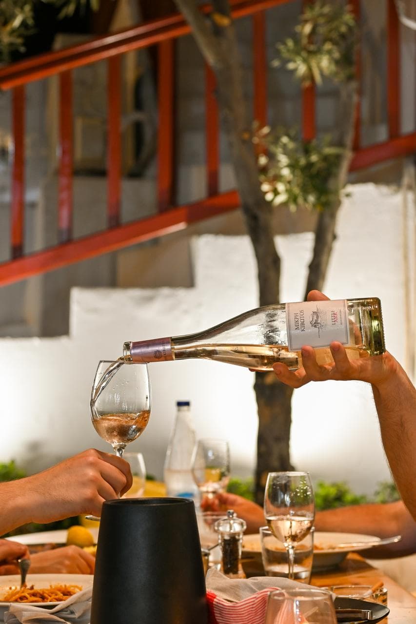 Chilled Greek rosé poured at the table.